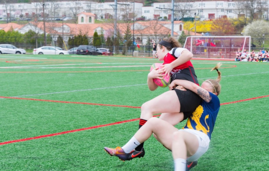 Montclair State University club women's rugby player tackling the opponent