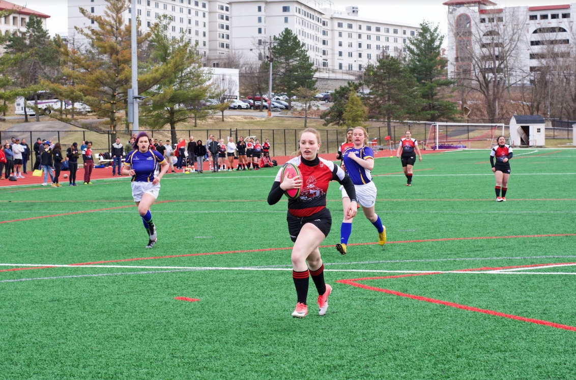 Montclair State University club women's rugby player running down the field