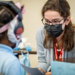 Second-year audiology student Cindy Fernandez tests a Newark child’s hearing using an audiometer.