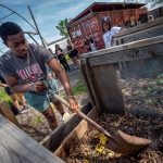 Richard Steiner-Otoo, a junior majoring in Geographic, Environmental and Urban Studies, turns a compost pile at Down Bottom Farms. The site has evolved from an abandoned and contaminated freight rail yard into a community asset that promotes sustainability and food justice.