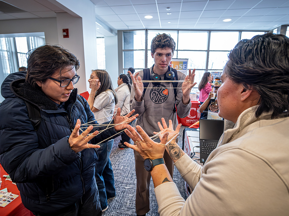 Students at an event use string and their hands to try the Navajo String Game