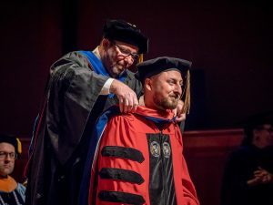 Garrett Nieddu being hooded at commencement