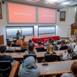 Wamwari in front of room full of students in lecture hall