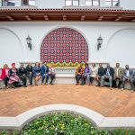 Group of attendees seated, flanking new sign