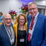 Three people pose for a photo.