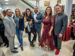 A group of three men, three women, stand close to one another