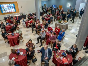 A wide shot of the room with multiple tables and guests sitting.