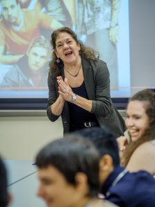 Smiling professor makes students laugh in class