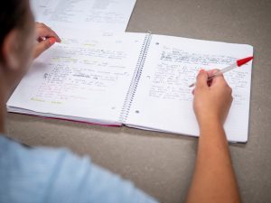 hands writing in notebook
