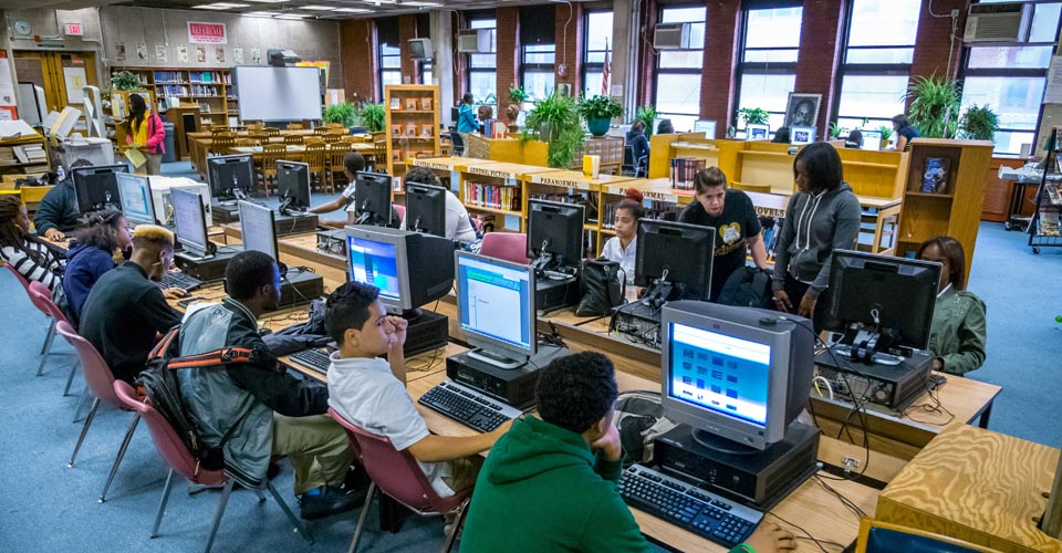 Photo of students using computer stations in the school library.