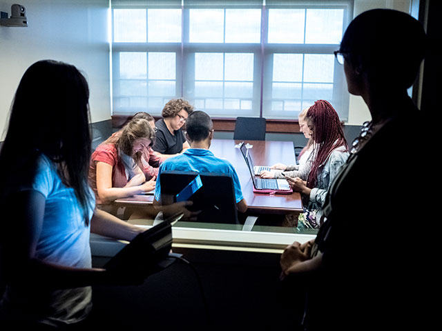 Montclair State University students in a meeting space in the Feliciano School of Business.