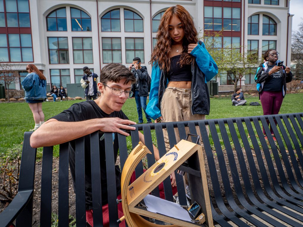Physics major Louis Araujo adjust a "sunspotter," which projects the Sun's image and allows a safe viewing of the eclipse.
