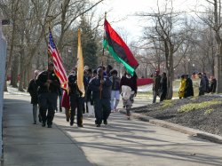 Photo of people marching on campus and holding flags