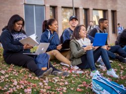 Group of students sitting outside and smiling