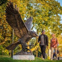 Montclair State Students walk past the Red Hawk statue