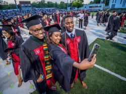 three students posing for selfie at convocation