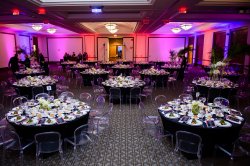 The Main Ballroom of the Conference Center set up with multi-colored lighting and tables and chairs.