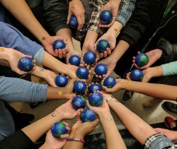 Multiple hands coming into the center holding stress balls