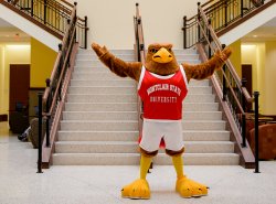 Red Hawk mascot stands in atrium of business school building