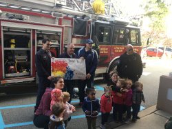 Young children posing with Little Falls Fire Fighters and fire truck