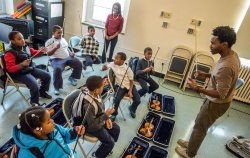 University Americorps volunteers teaching music class to kids.