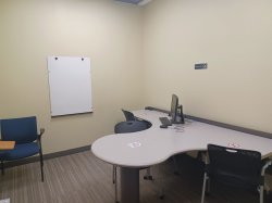Study room with table, chairs, computer, and whiteboard