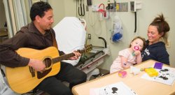 Atlantic Health System music therapist Danny Marain plays guitar for a patient and mother at the Newton Medical Center.