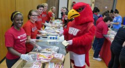 Rocky the Red Hawk joins Montclair State volunteers in making sandwiches for local homeless shelters and soup kitchens, one of the many service activities during the National Day of Service.