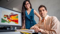 Environmental Studies Assistant Professor Jorge Lorenzo Trueba and doctoral candidate Isamar Marie Cortés in front of map