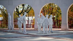 Photos of white statues that look like people milling around on the Montclair State campus.