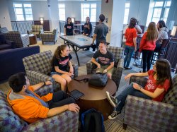 Students sitting around a Residence Hall common area hanging out.