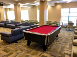 Another picture of the common area in Sinatra Hall featuring a pool table and some couches and chairs.