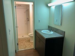 The bathroom at a Hawk Crossing's Apartment featuring a vanity and sink with a separate room for shower and toilet.