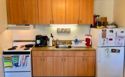 A view of the kitchen counter space, fridge and stove at a mult-floor Hawk Crossings apartment.