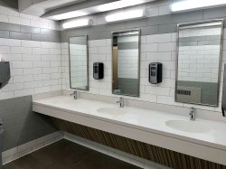 The bathroom in Stone Hall featuring three sinks and mirrors.