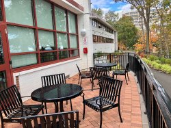 The outside patio of Stone Hall with table and chairs and a view of the New York skyline.