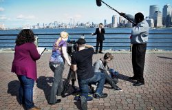 Photo of production crew doing an interview in front of NYC skyline.