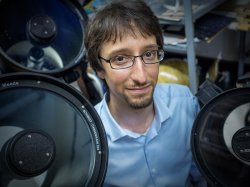 Professor Marc Favata surrounded by physics equipment.