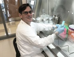 Professor Carlos Molina in lab coat performing research.