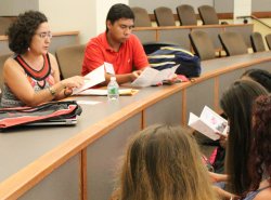 Photo of Prof. Maria Jose Garcia Vizcaino sitting and talking with students at an orientation session.
