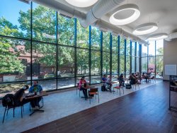 Students sitting in the dining area of the Student Center with giant windows.