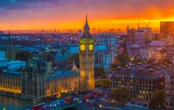 Photo of sunset over london with Big Ben and surrounding buildings lit up.