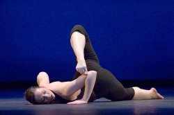 Photo of dancer on the ground in contortionist pose.