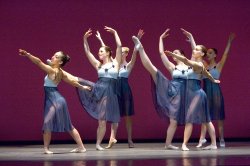 Photo of six dancers in flowing lavender skirts.