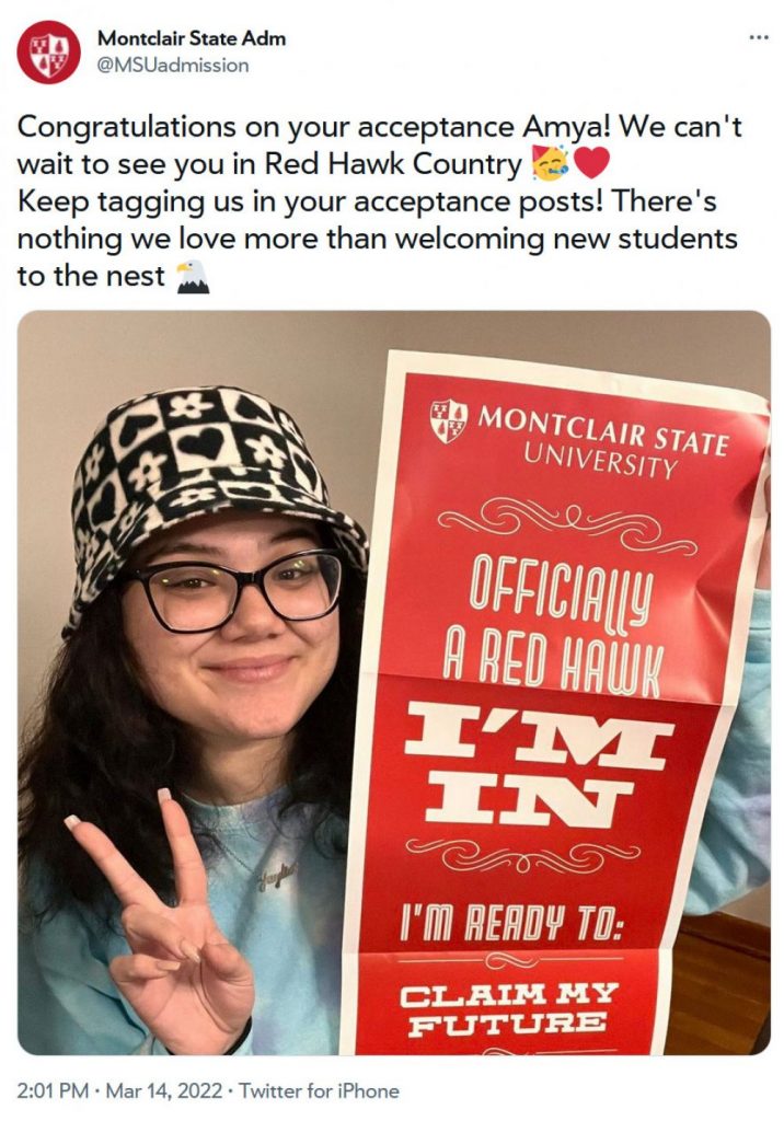 student holding "officially a Red Hawk" sign