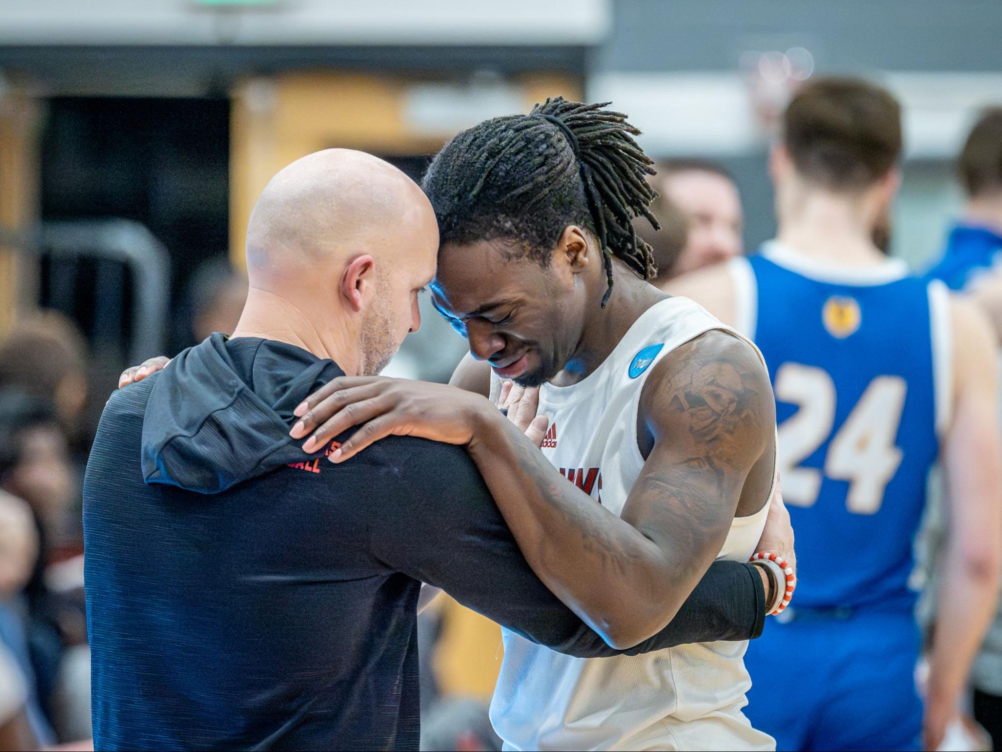Coach and basketball player touching foreheads. 