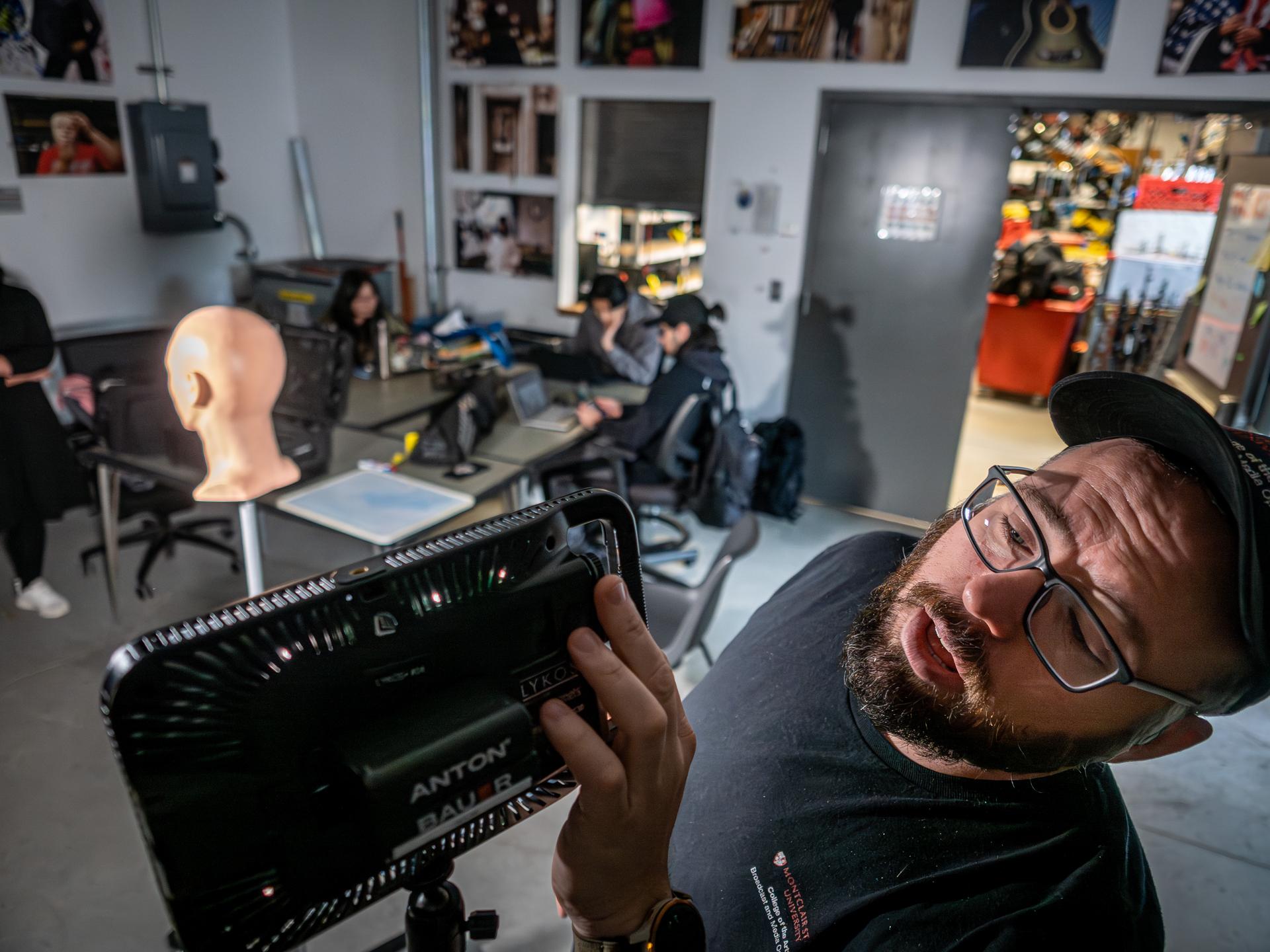College of Communications and Media film cage supervisor Frank Martinez giving students a lighting tutorial.