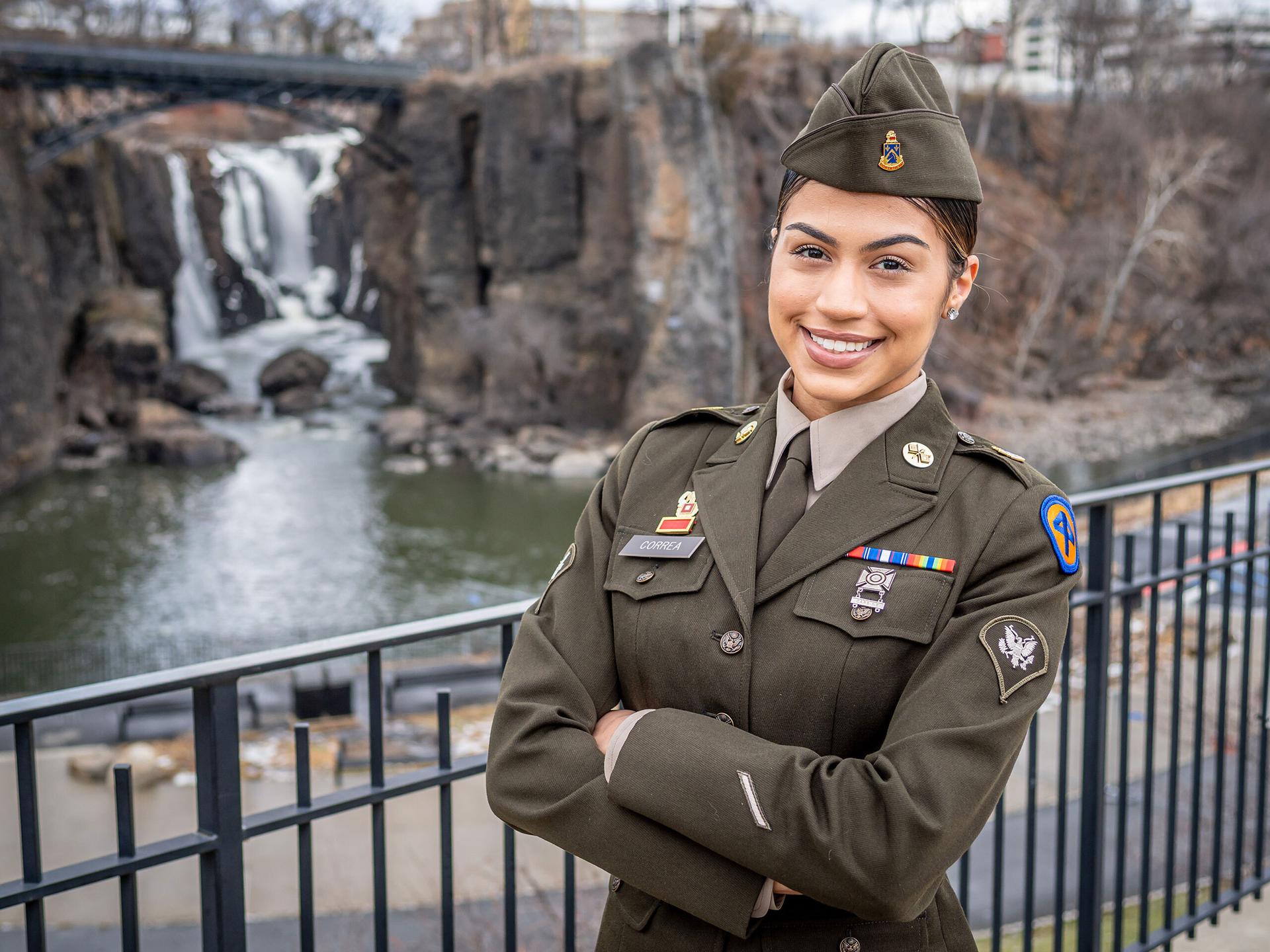 Brianna Correa, wearing her National Guard Army Green Service Uniform, modeled after WWII-era attire, at the Paterson Great Falls, reflecting her strong connection to her hometown city.