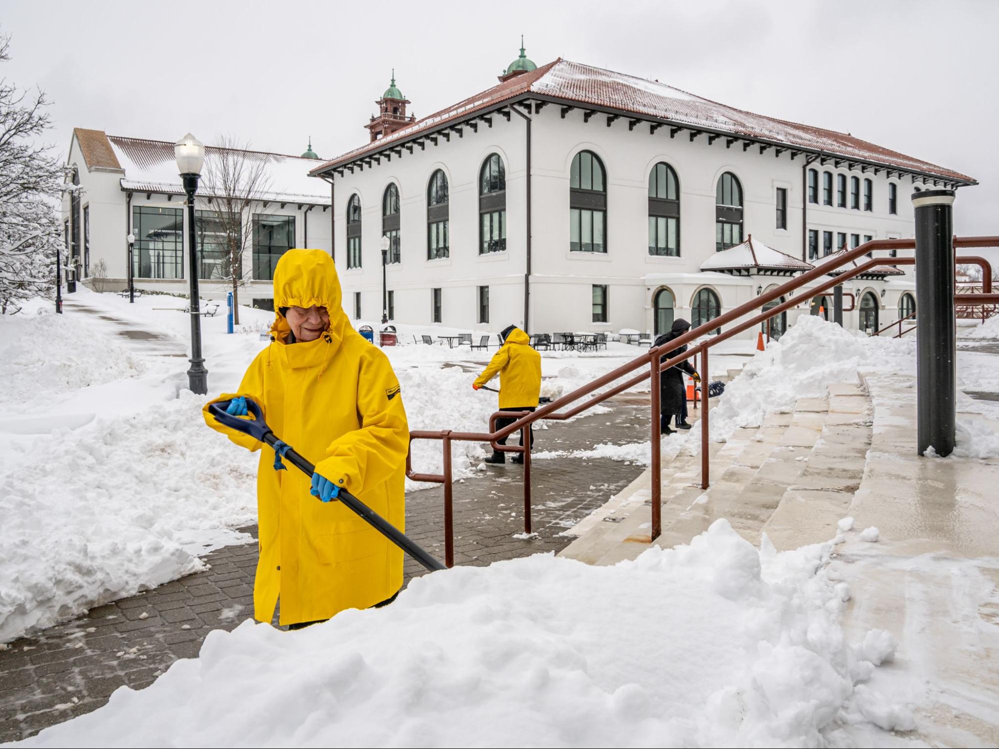 Facility workers shoveling Montclair State University's campus after a blizzard.