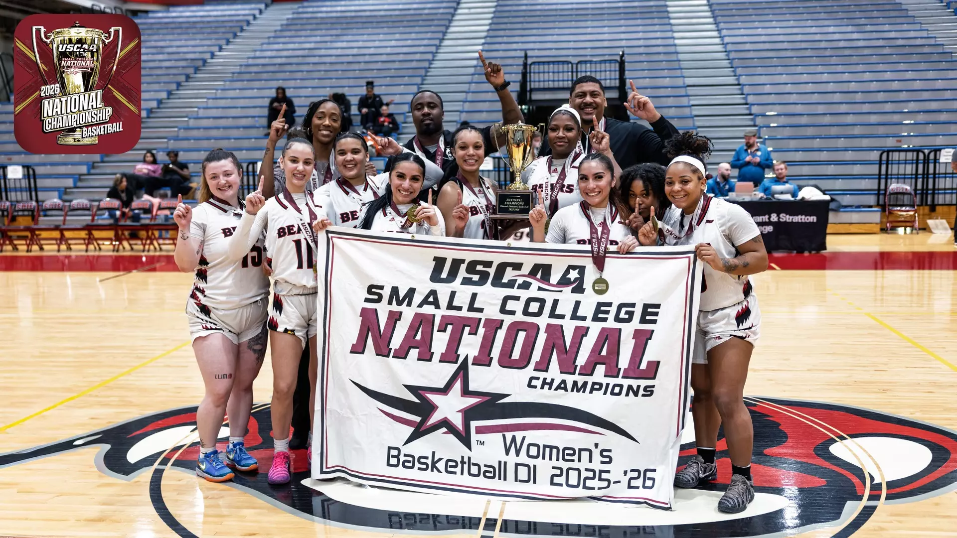 Women’s Basketball team posing with championship banner.